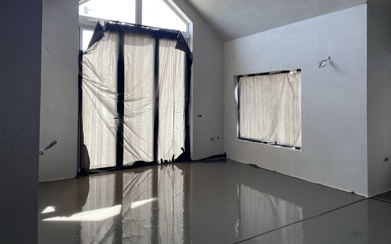 Liquid screed flooring poured in vaulted bedroom with apex window